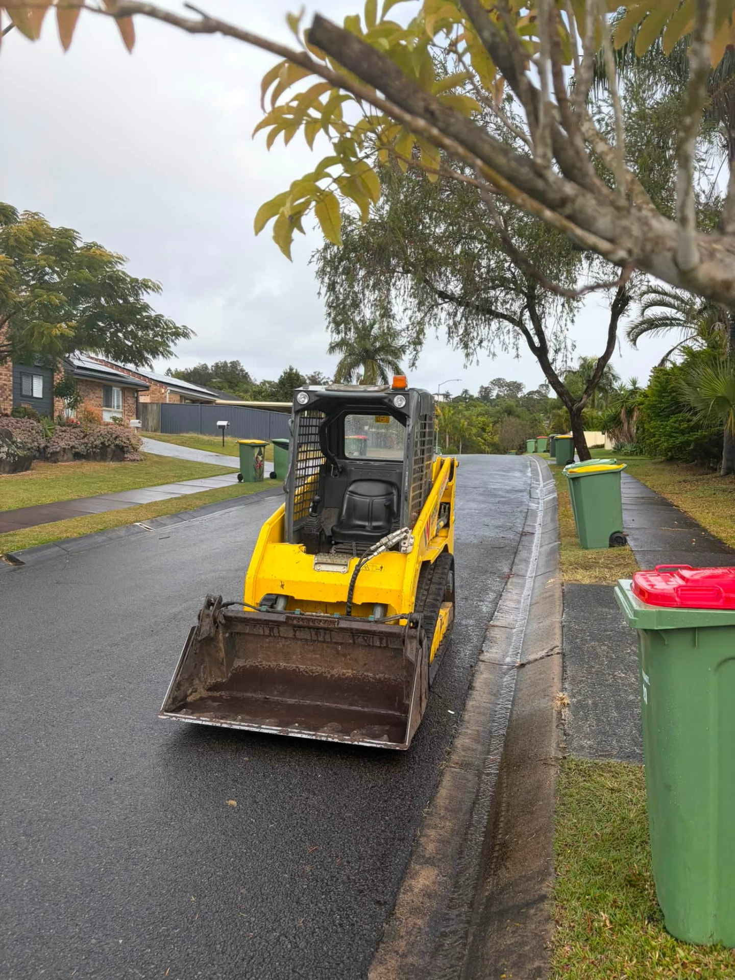Posi track loader ready for landscaping work on a residential street